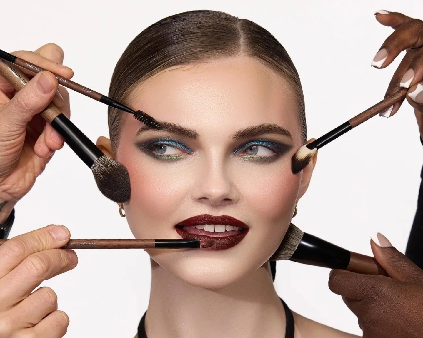 Femme avec maquillage, plusieurs pinceaux autour du visage.