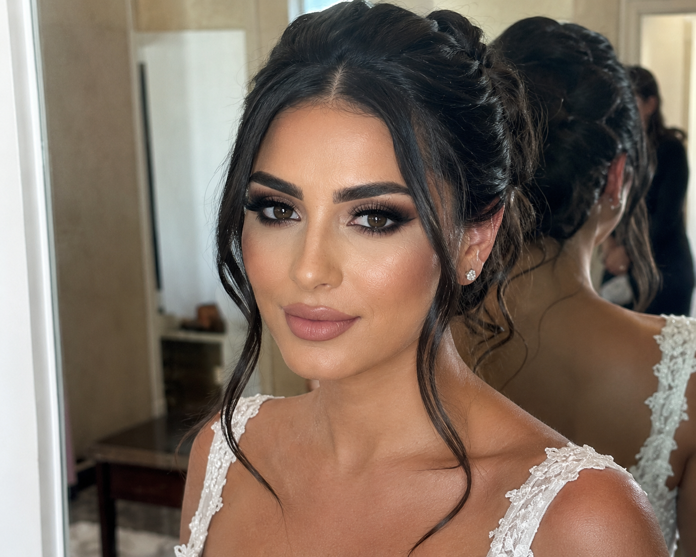 Mariée élégante au chignon devant un miroir